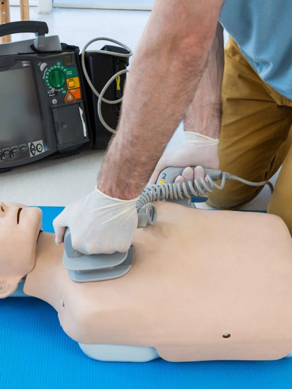 Paramedic practicing resuscitation on dummy in clinic